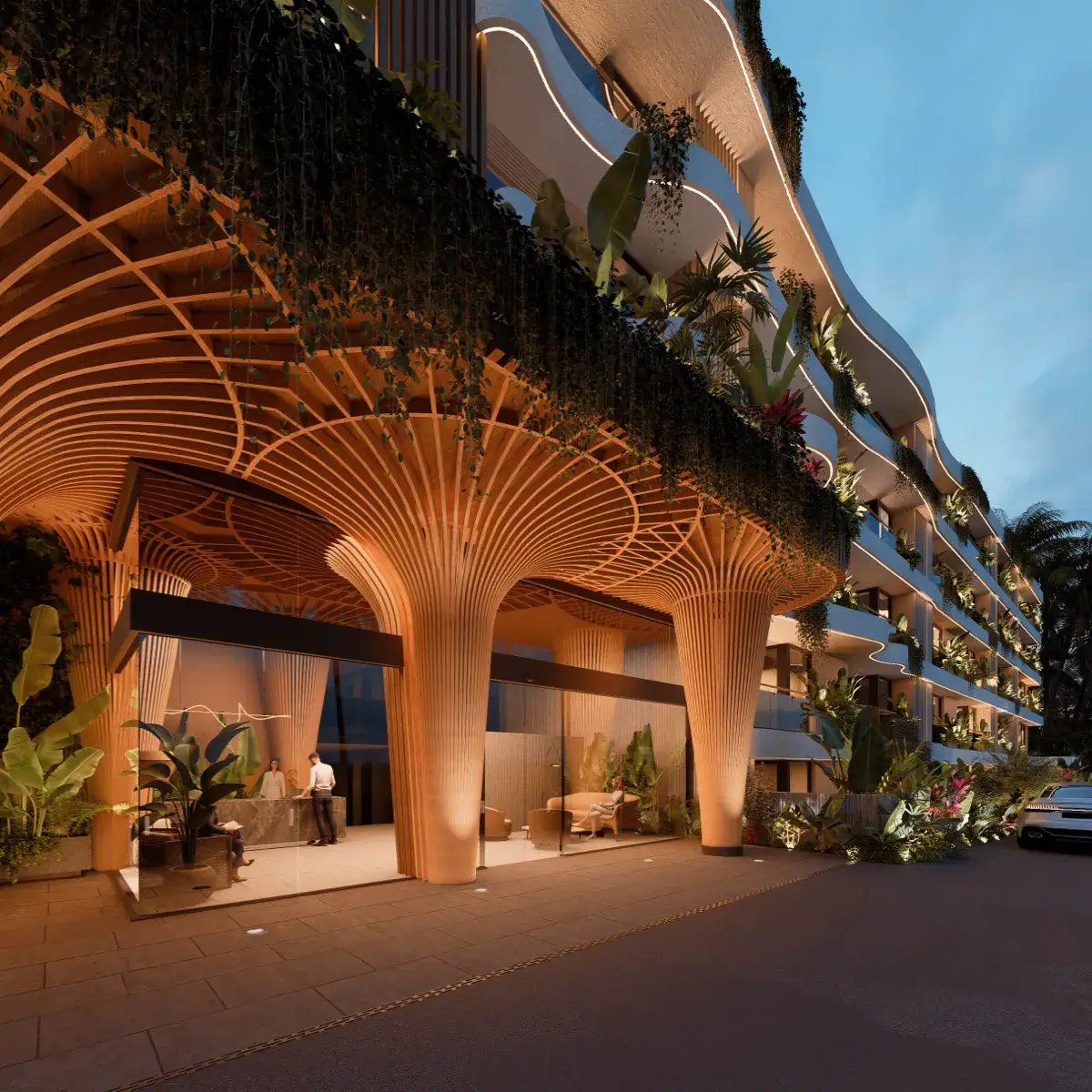 Ground-level view of a modern building with unique wooden architectural columns, illuminated by warm lights, featuring hanging plants and greenery around the entrance.